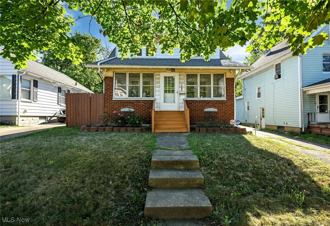 View of front of property with brick siding and roof with shingles