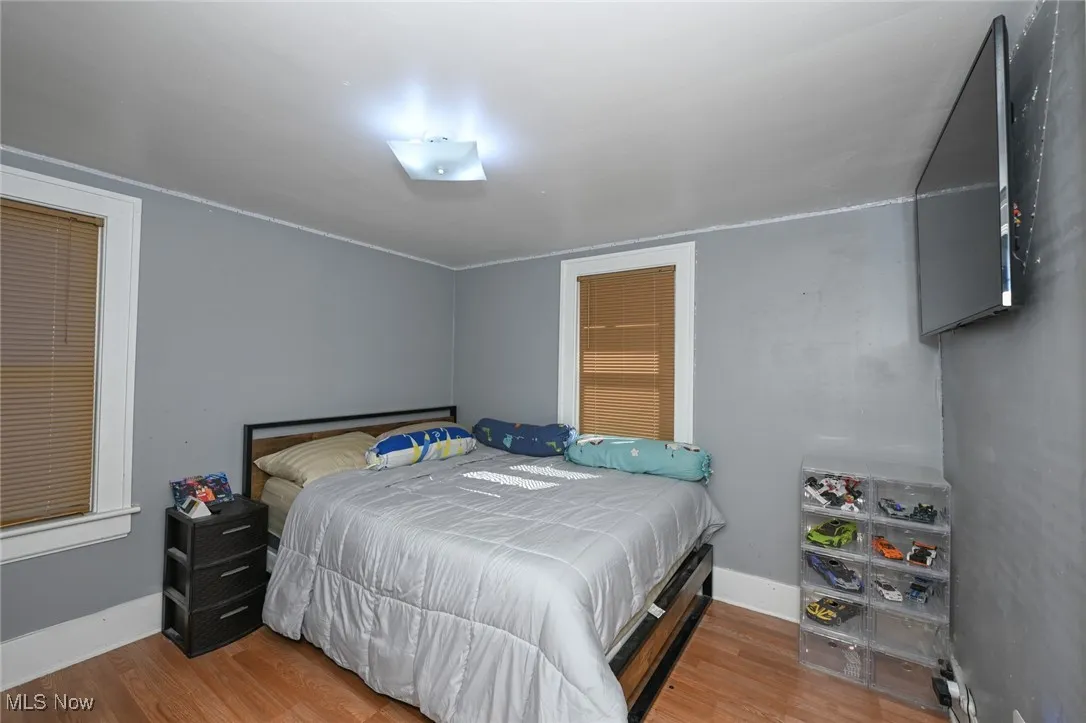 Bedroom with light wood finished floors and baseboards