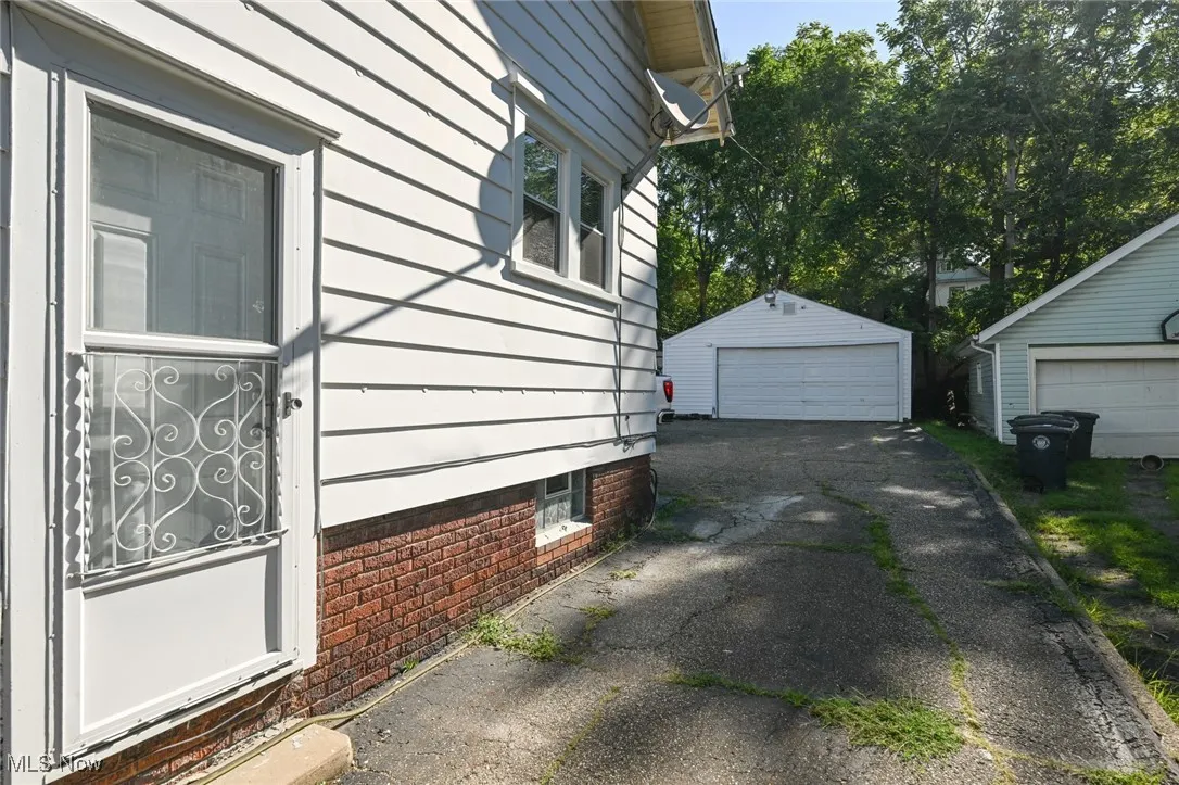 View of side of property featuring an outdoor structure and a detached garage