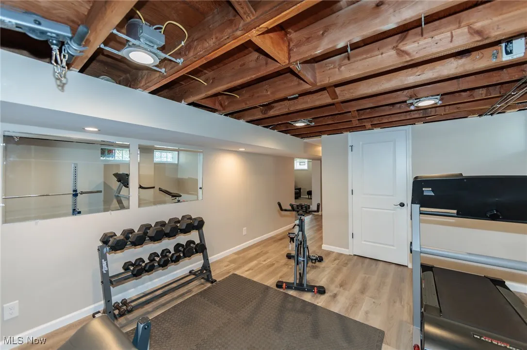 Exercise room with light wood-style flooring and baseboards