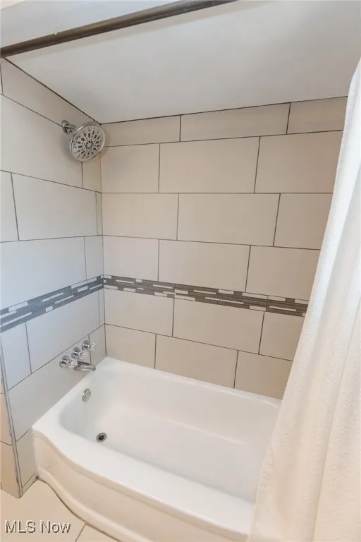 Bathroom featuring shower / bath combo and tile patterned floors