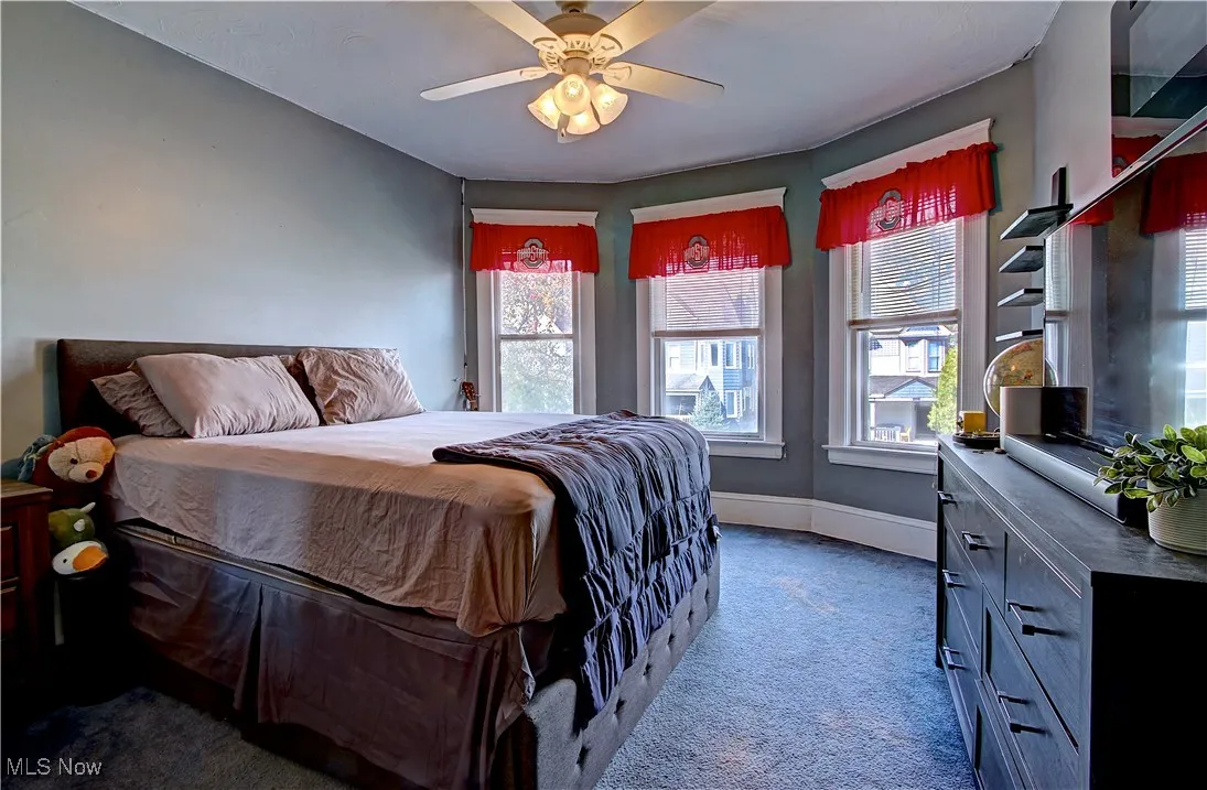 Bedroom with dark carpet and ceiling fan