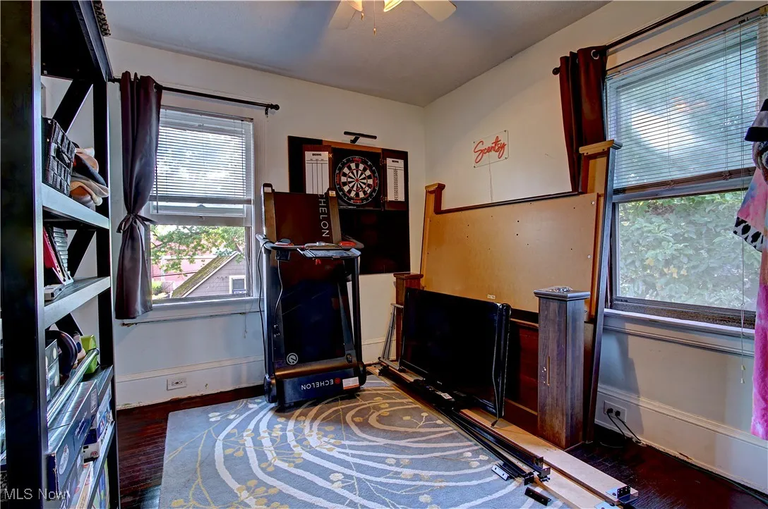 Home office with dark wood finished floors and a ceiling fan