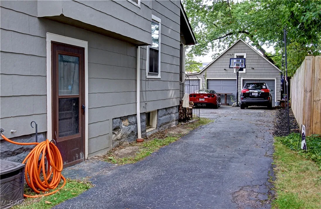 View of side of property with an outdoor structure and a detached garage