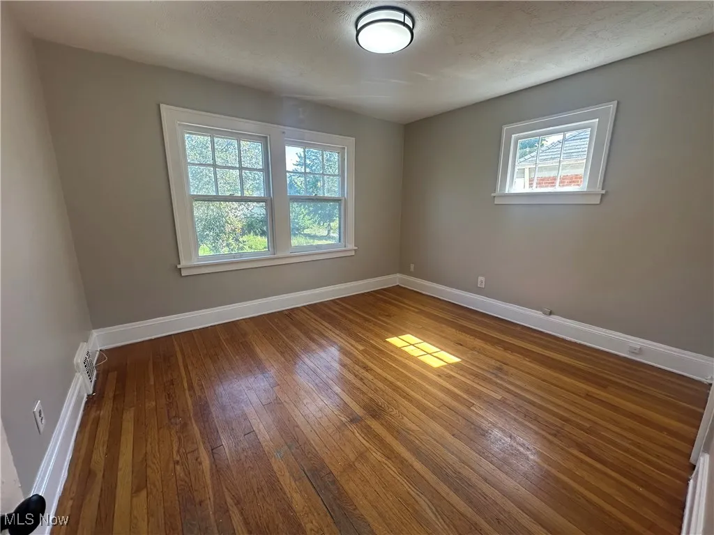 Spare room featuring hardwood / wood-style floors and a textured ceiling