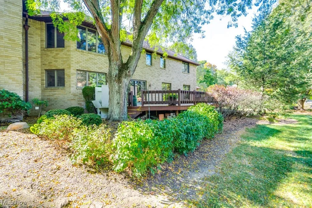 Back of house with brick siding and a wooden deck