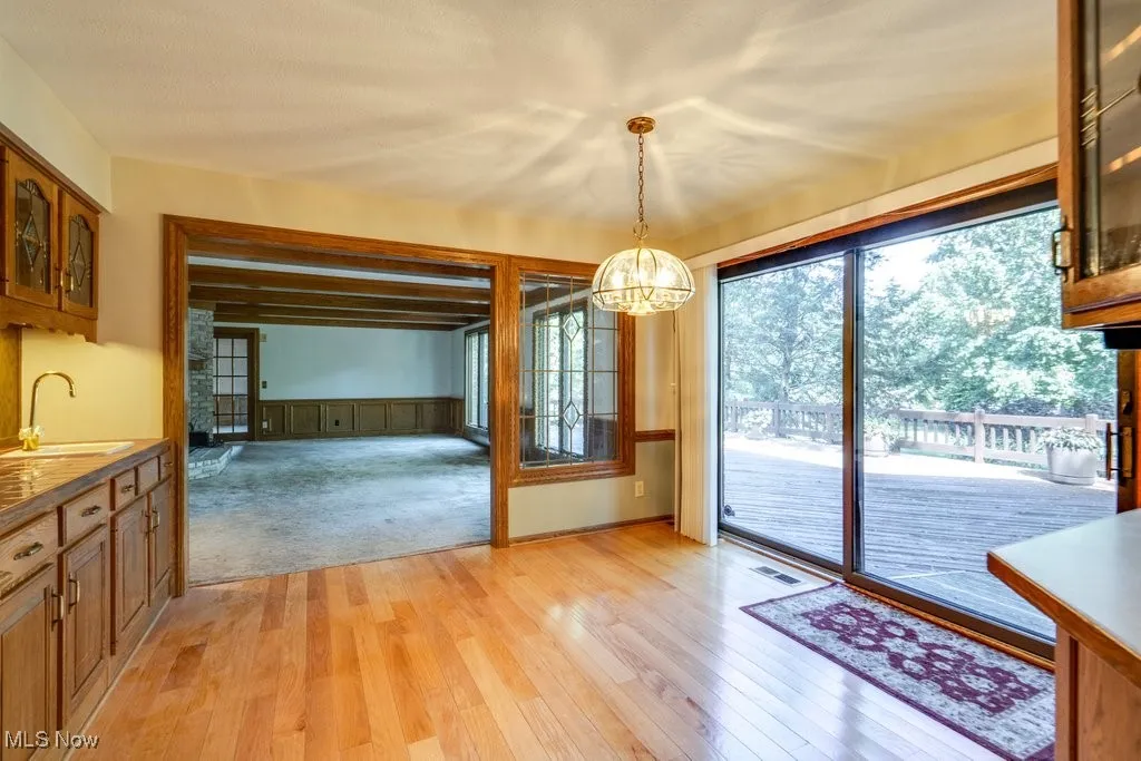 Eat-in Kitchen area with additional cupboards and sink and wood flooring.  Notice the decorative window between lfamily room and Kitchen and sliding glass doors leading to the expansive deck and yard.