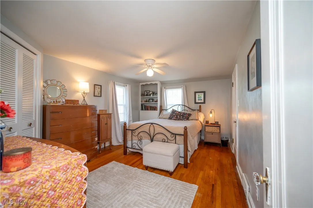 Bedroom featuring wood finished floors, a closet, and a ceiling fan