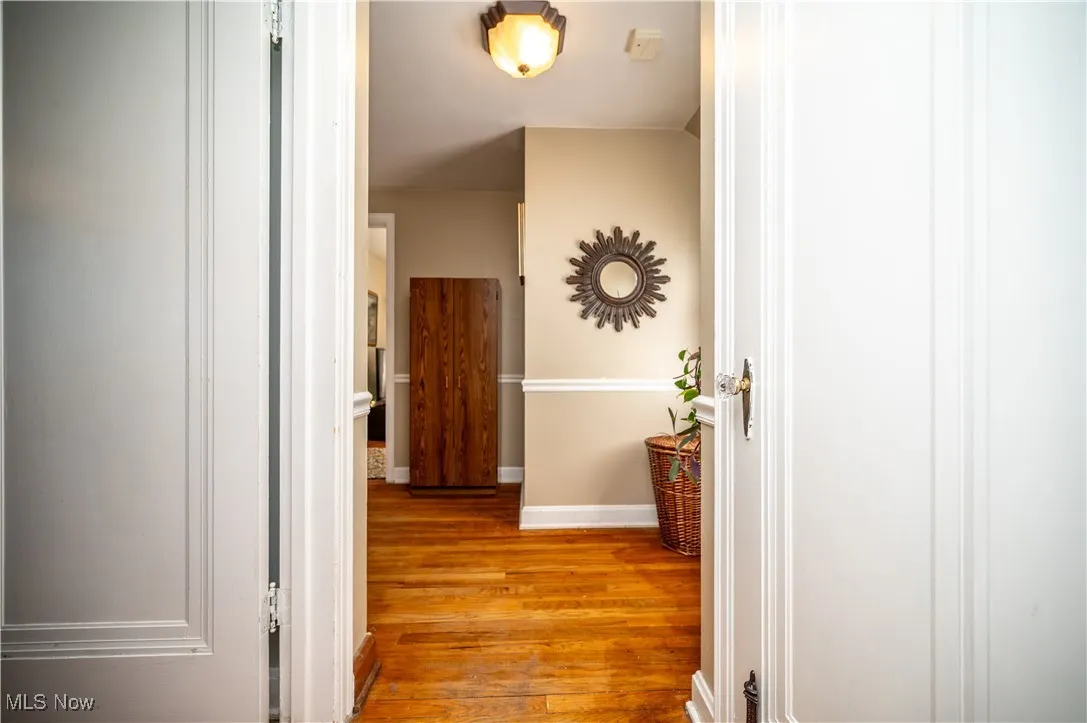 Hall with wood-style floors and baseboards