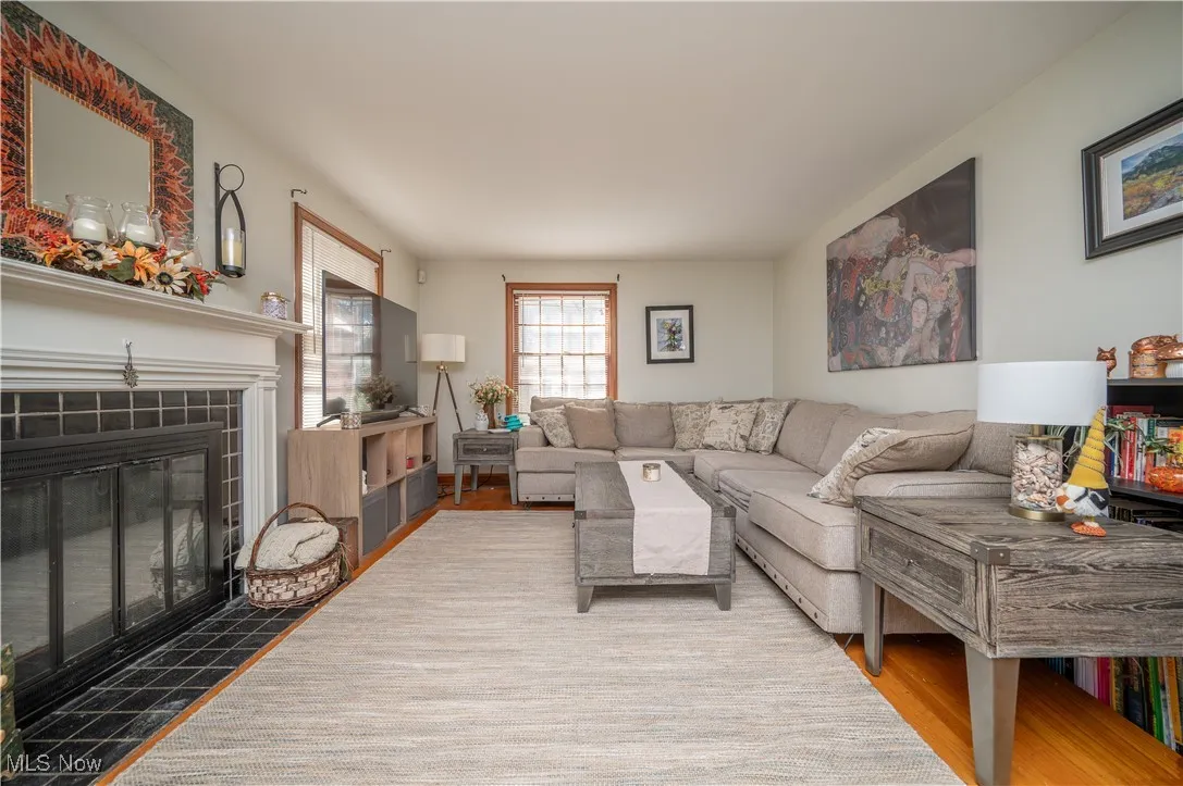 Living area with a tile fireplace and wood finished floors