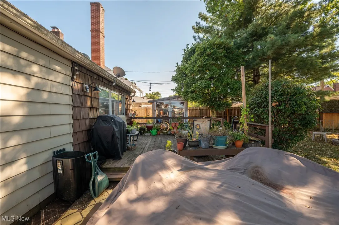 Wooden deck with a fenced backyard and area for grilling