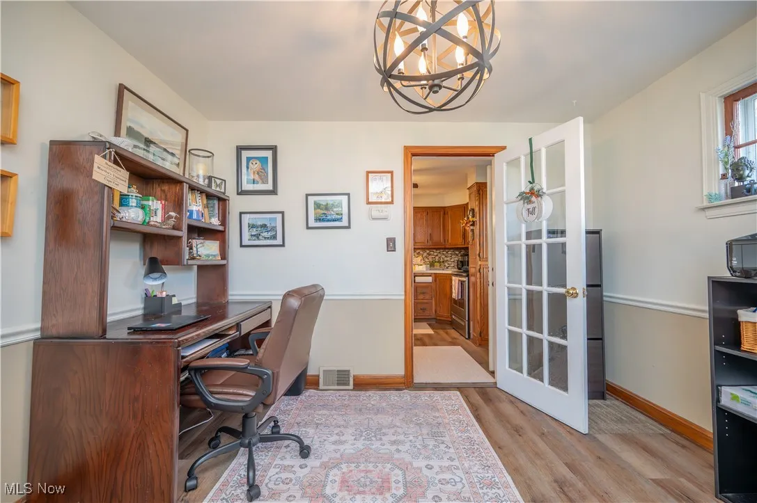Dining room featuring arched walkways, wood-type flooring, and a chandelier