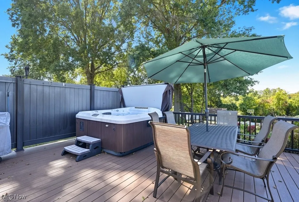 Wooden terrace featuring a hot tub and outdoor dining space