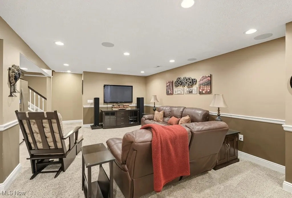Living area with recessed lighting, stairway, and light carpet
