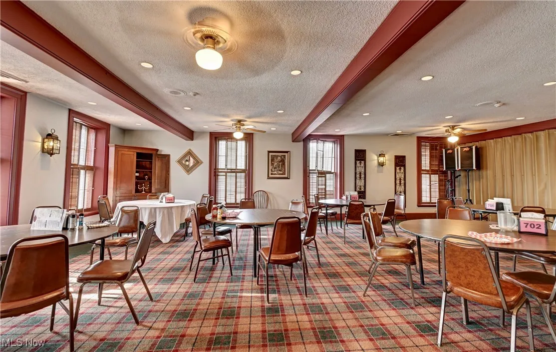 Dining space featuring beam ceiling, a textured ceiling, a ceiling fan, and recessed lighting