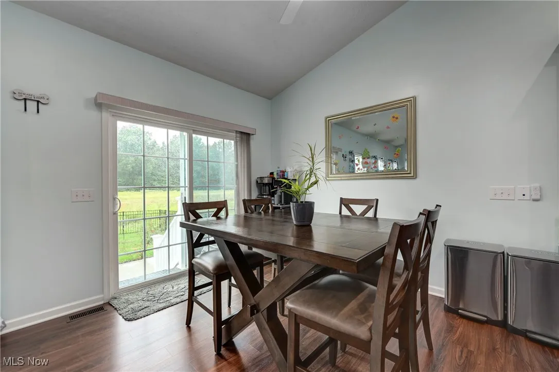 Dining space with vaulted ceiling and dark wood finished floors