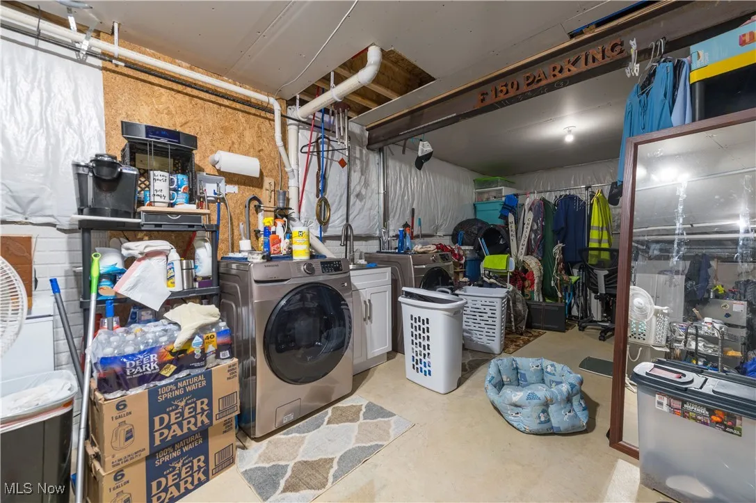 Below grade area with separate washer and dryer and a sink