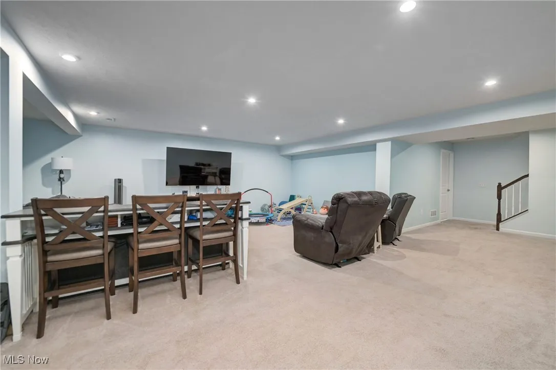 Living area with recessed lighting and light colored carpet