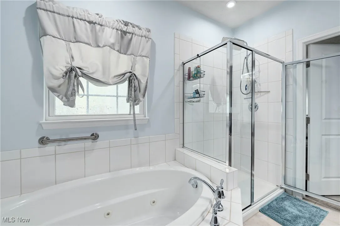 Full bathroom featuring a shower stall, a jetted tub, tile patterned flooring, and recessed lighting