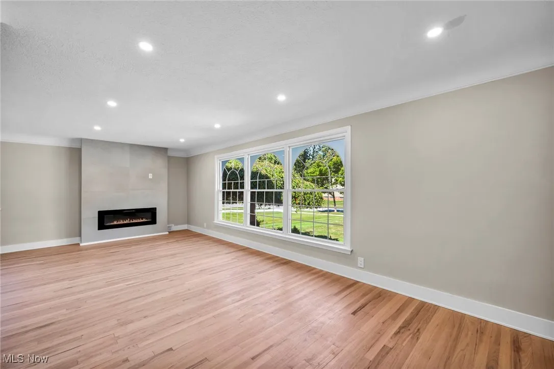 Unfurnished living room with light wood finished floors, recessed lighting, a fireplace, and a textured ceiling