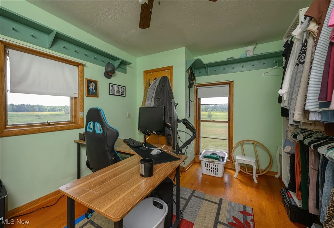 Office featuring wood finished floors, a textured ceiling, plenty of natural light, and ceiling fan