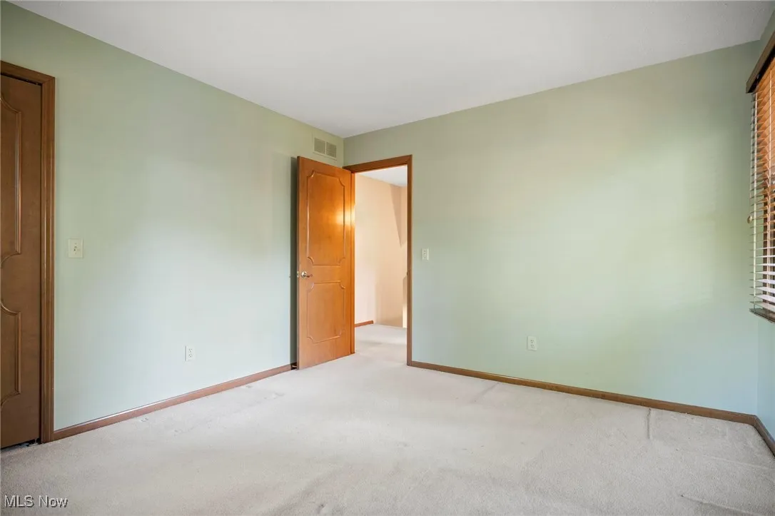 Unfurnished bedroom with carpet flooring and baseboards