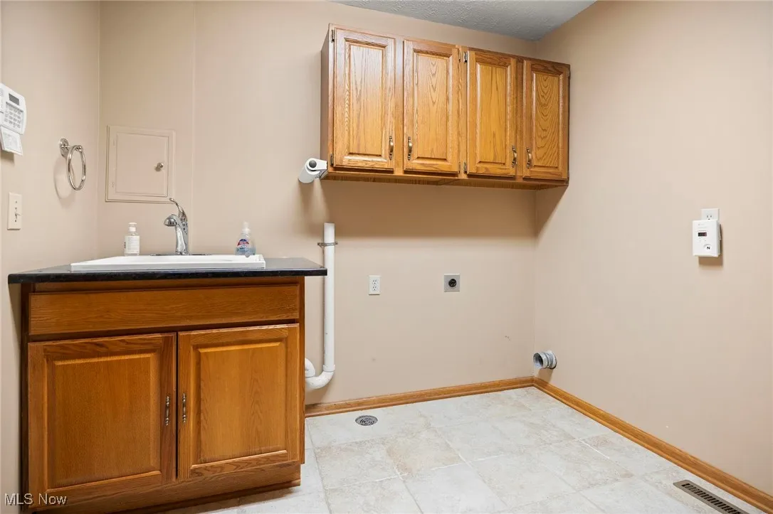 Washroom with cabinet space and electric dryer hookup