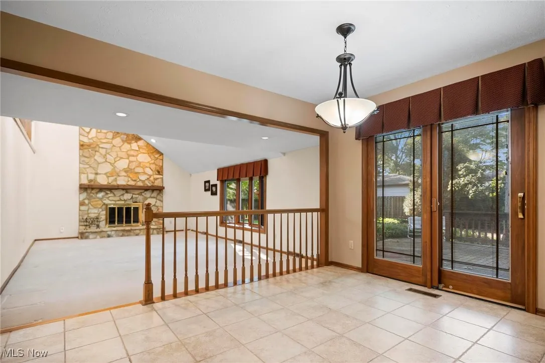 Entryway with vaulted ceiling, a fireplace, tile patterned flooring, and recessed lighting