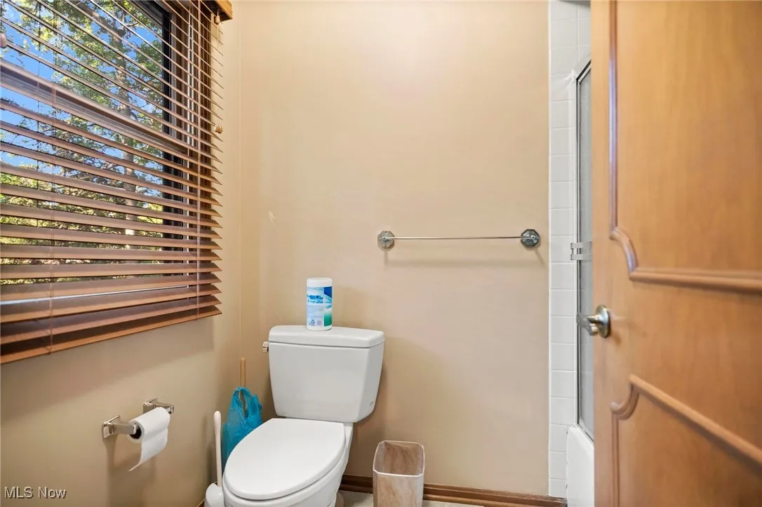 Full bathroom with toilet and enclosed tub / shower combo
