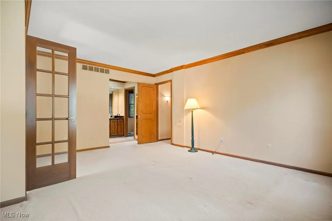 Carpeted empty room with baseboards and crown molding
