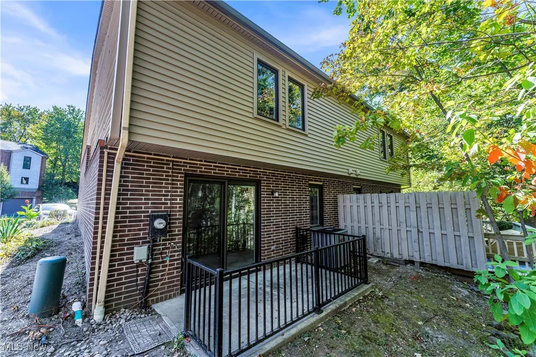 Back of property with a patio area and brick siding