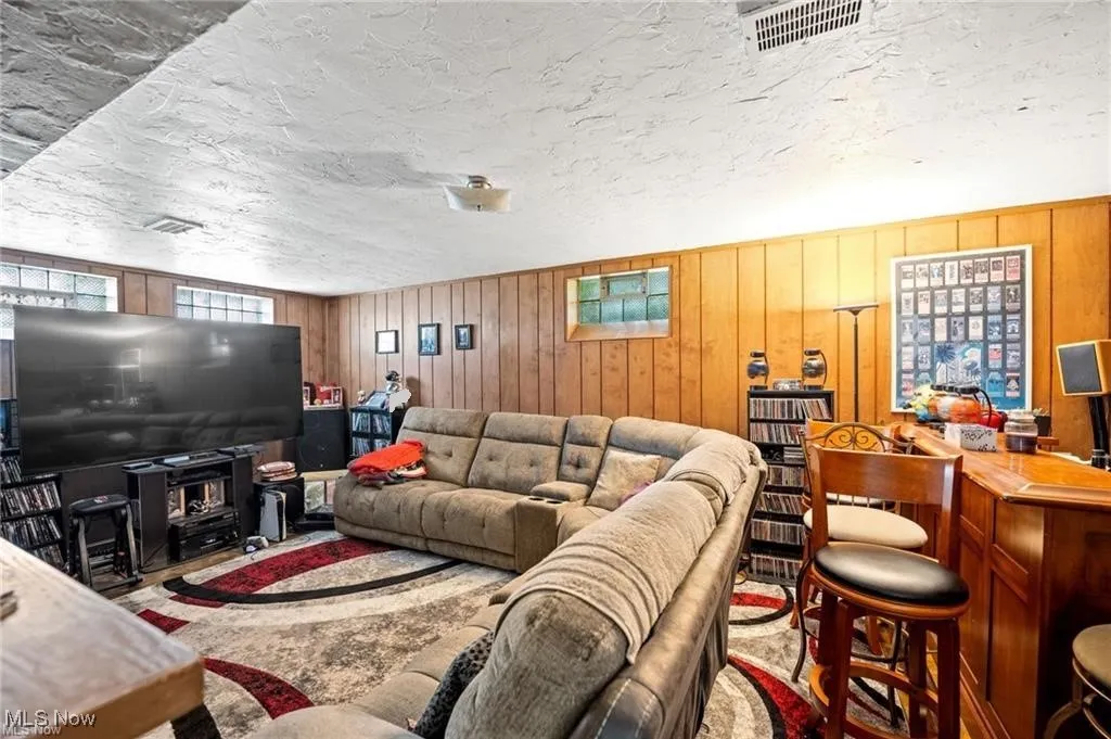 Living area with wooden walls and a textured ceiling