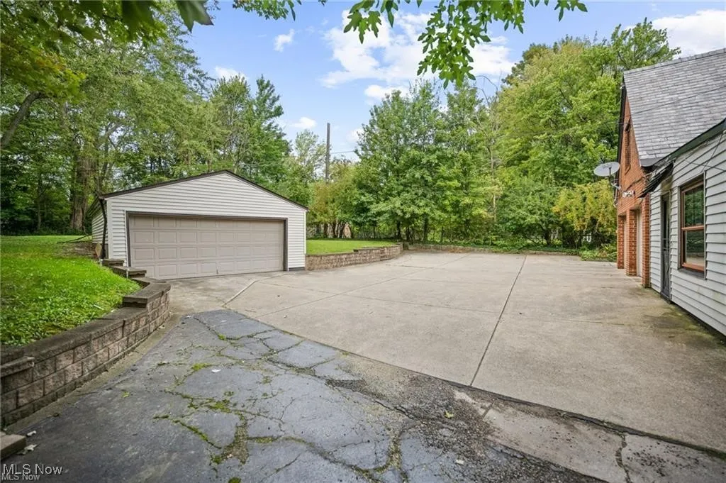 Detached garage with view of scattered trees