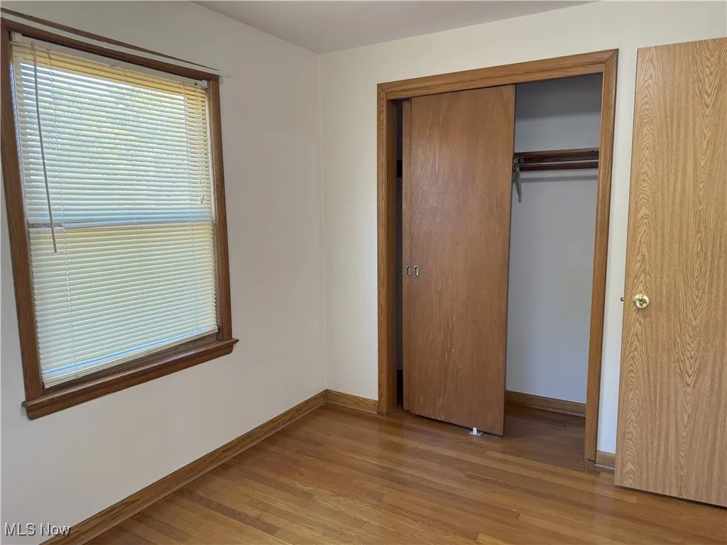 Unfurnished bedroom with light wood-style flooring and a closet