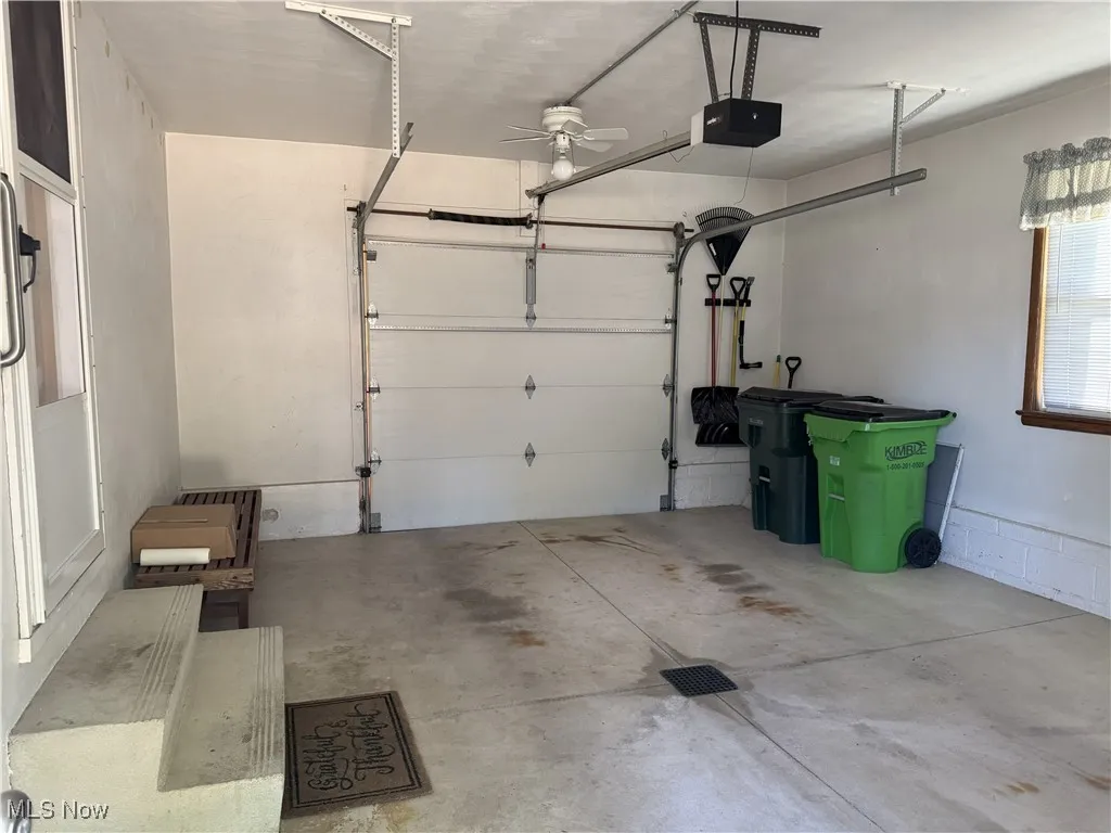 Garage featuring a garage door opener and a ceiling fan