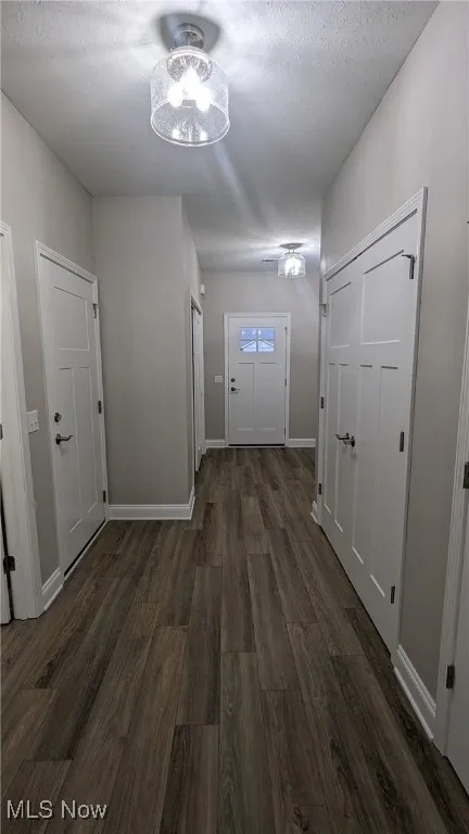 Hall with dark wood finished floors and a textured ceiling