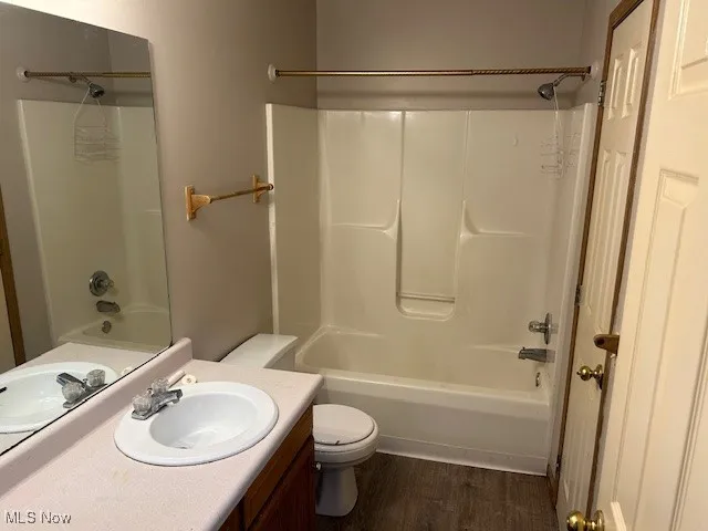 Full bathroom featuring bathtub / shower combination, vanity, and dark wood-style flooring