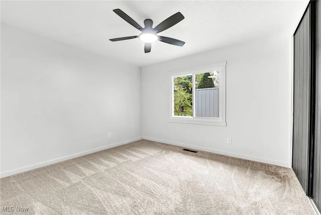 Unfurnished room with light carpet and ceiling fan