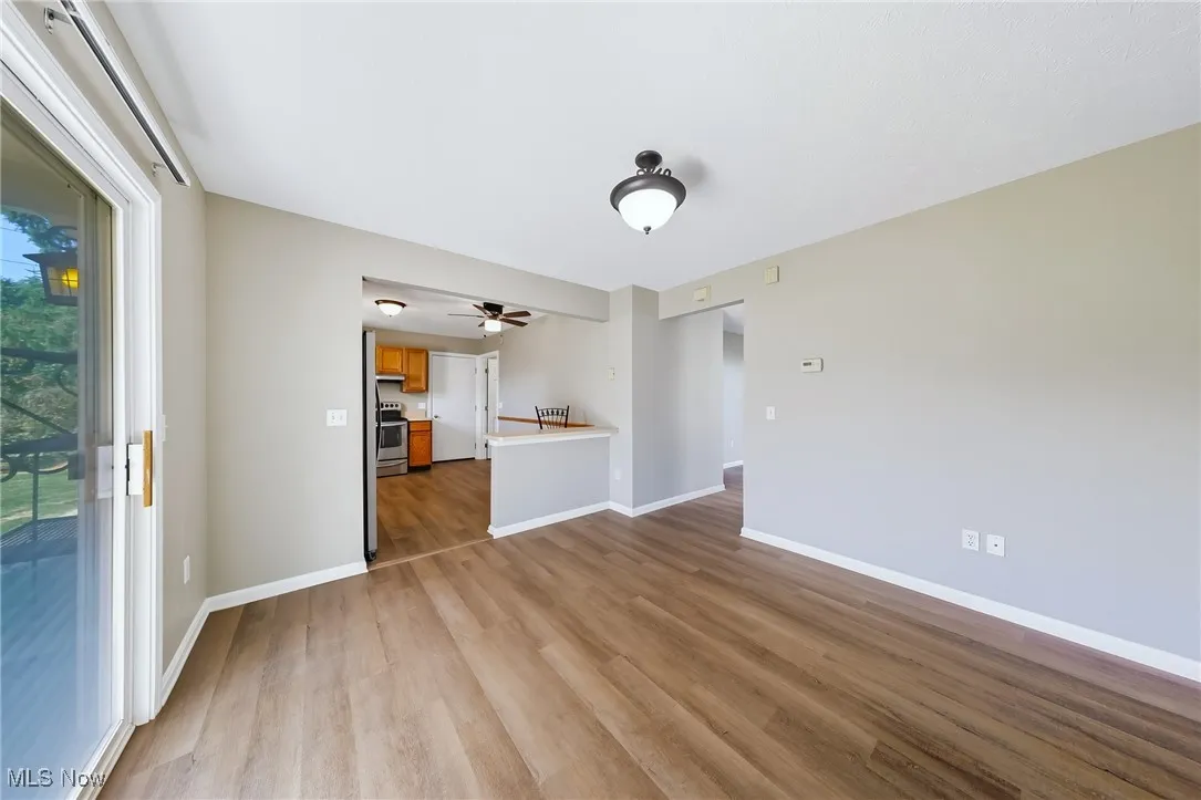 Unfurnished living room featuring light wood-style floors and ceiling fan