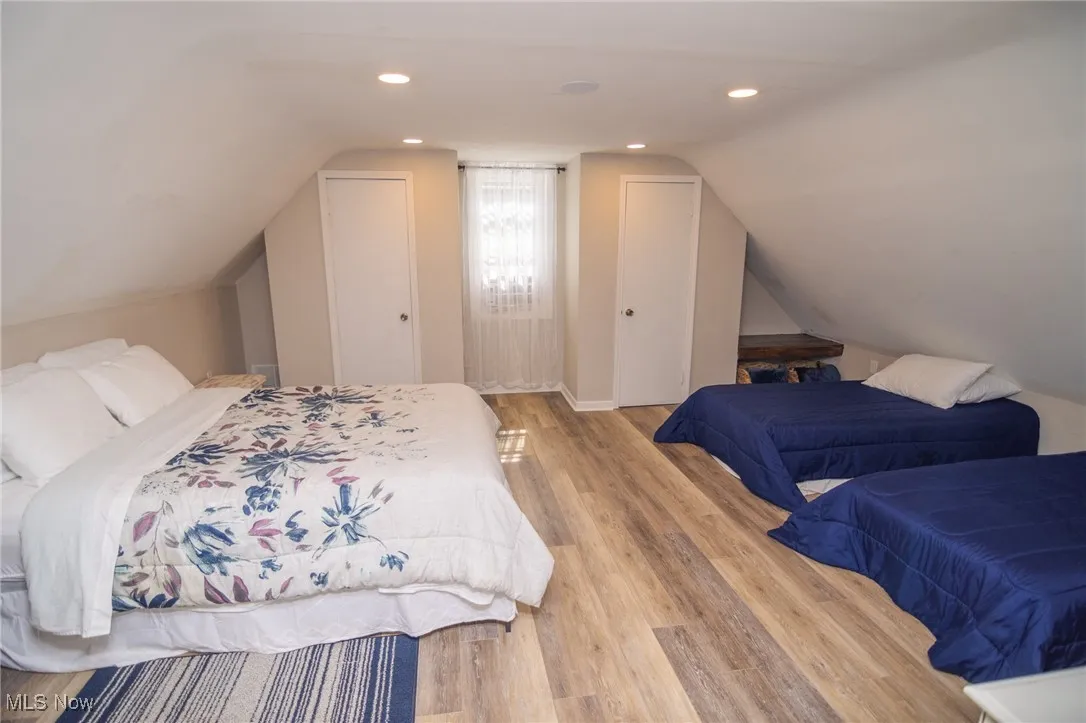 Bedroom featuring recessed lighting, lofted ceiling, and wood finished floors