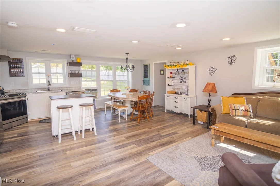 Living room with recessed lighting, wood finished floors, and a chandelier