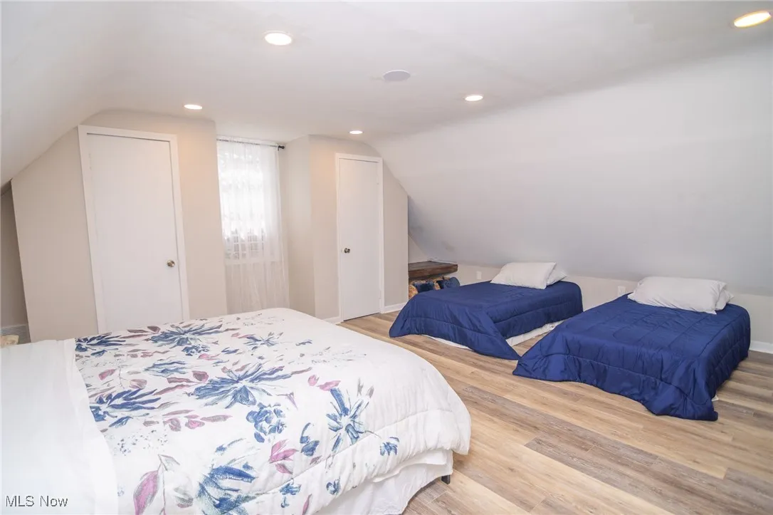 Bedroom featuring vaulted ceiling, wood finished floors, and recessed lighting