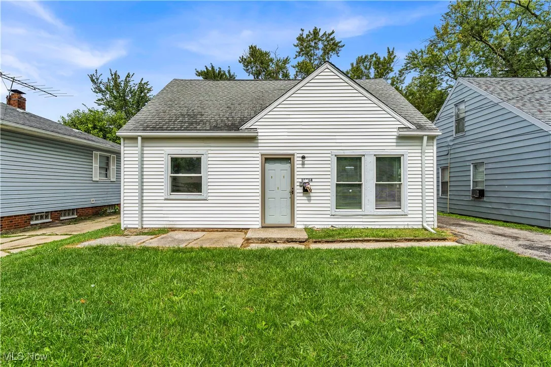 View of front of home with roof with shingles, a front lawn, and cooling unit