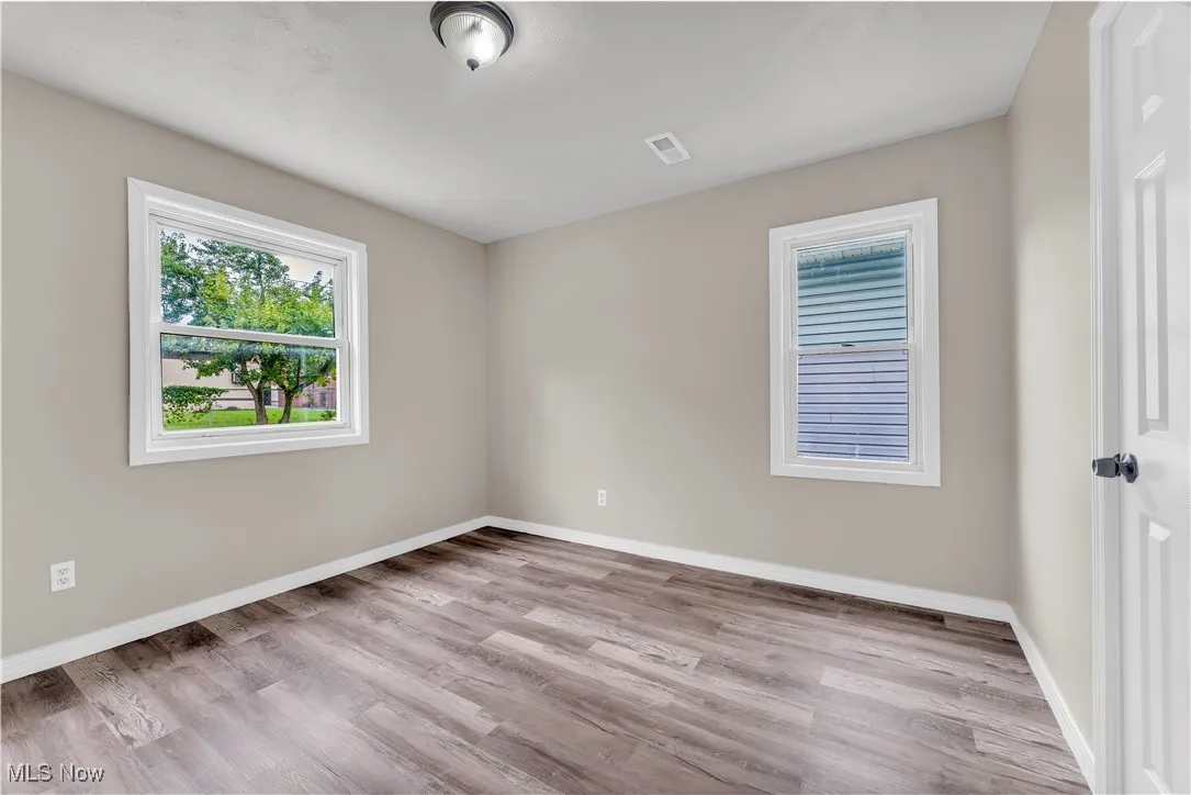 Empty room with light wood-type flooring and baseboards