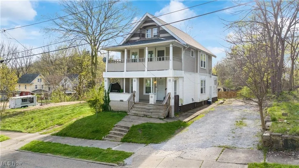 View of front of property featuring covered porch, driveway, and a front yard