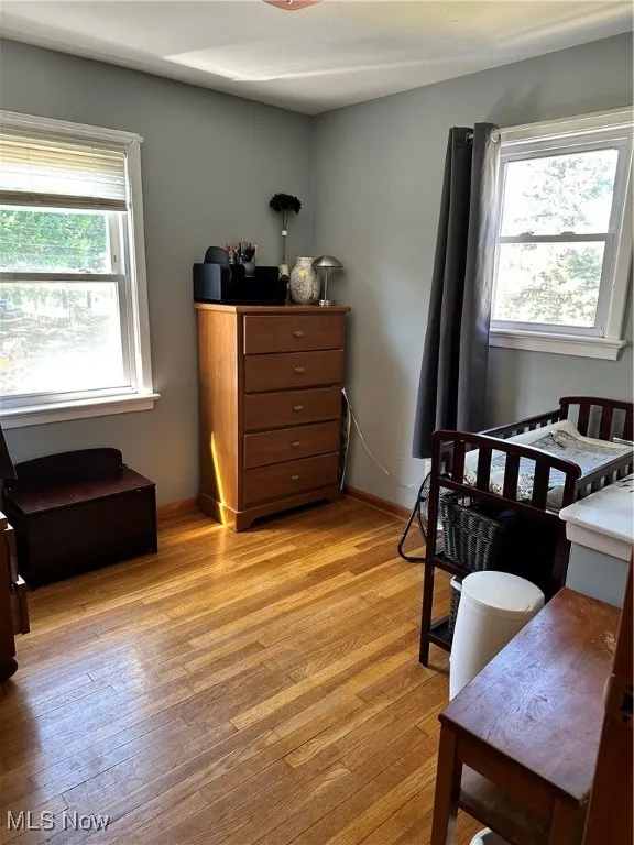 Bedroom with multiple windows and light wood-type flooring