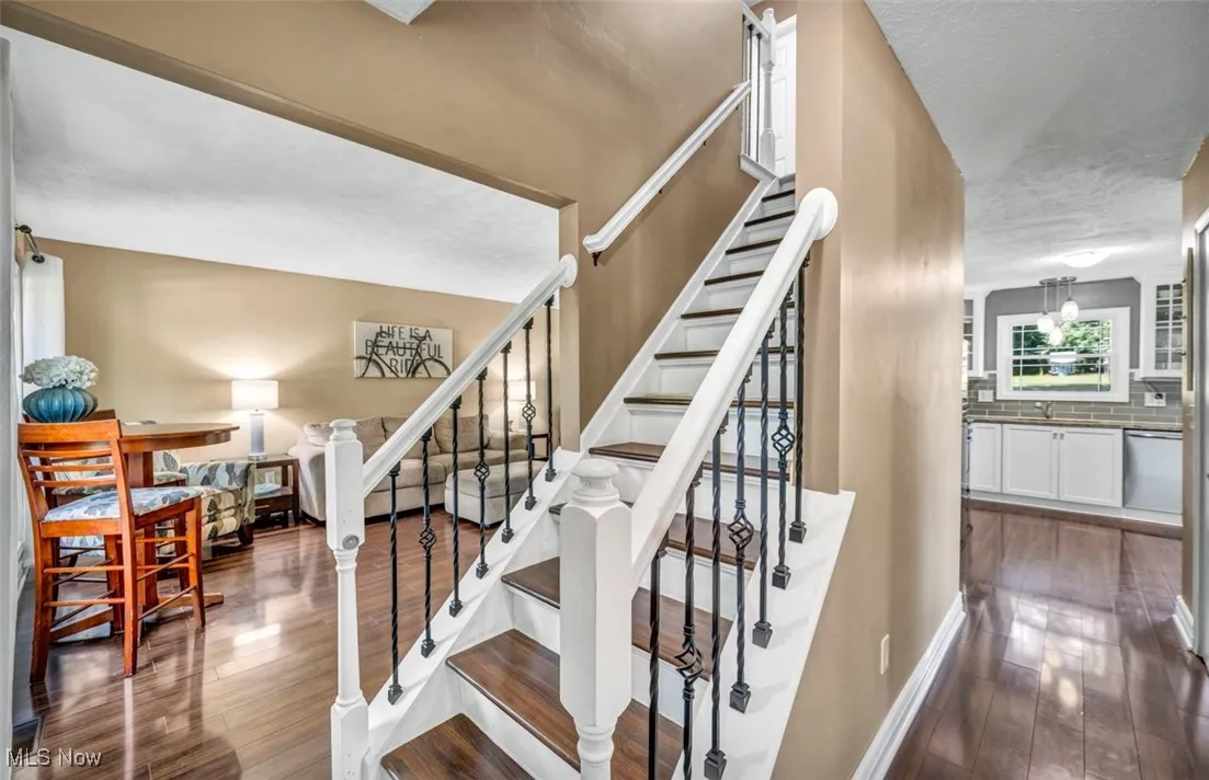 Stairs featuring hardwood / wood-style flooring and a textured ceiling