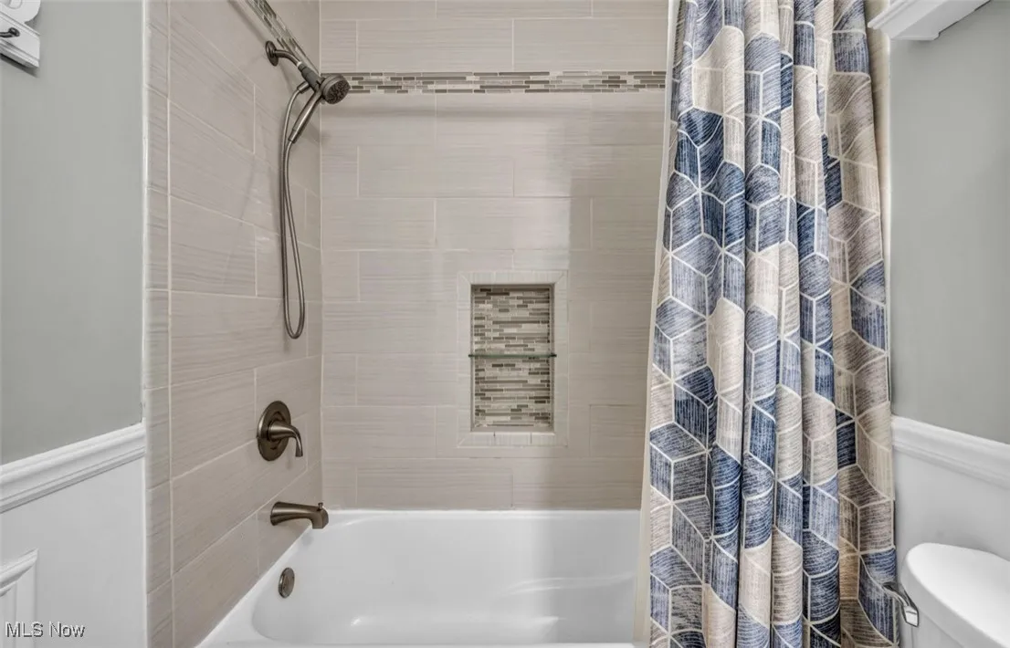 Bathroom with shower / bath combo with shower curtain and toilet