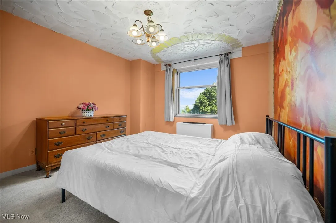 Bedroom featuring carpet and a chandelier