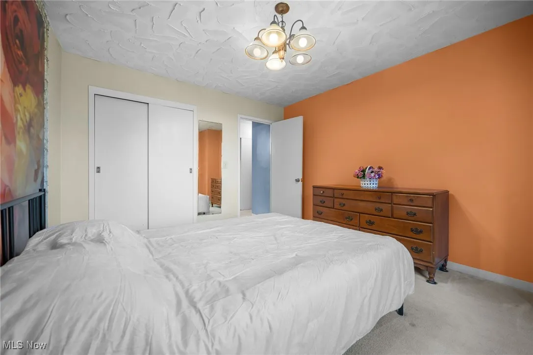 Carpeted bedroom with a closet and baseboards